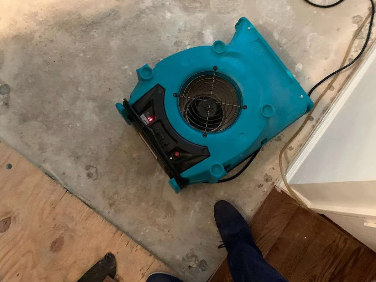 Air mover drying subfloor during Commercial Water Damage Restoration in Kaysville
